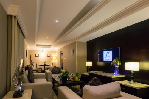a living room with couches and a flat screen tv at Holiday Jazan Hotel in Jazan