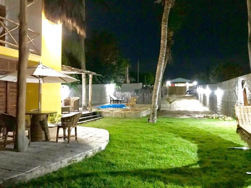 a backyard at night with a table and chairs at BougainVilla Guest House in Barra Grande