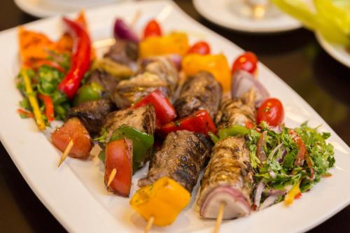 a plate of food with meat and vegetables on a table at Holiday Jazan Hotel in Jazan