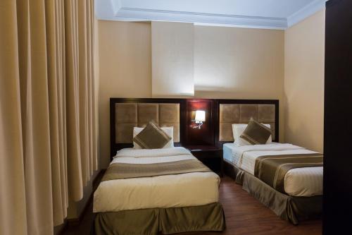 a hotel room with two beds and curtains at Holiday Jazan Hotel in Jazan