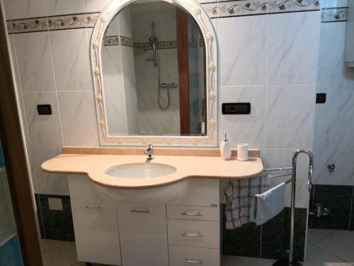 un baño con lavabo y espejo en Leo home, en Aosta