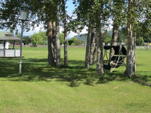 a park with a playground with a tree at Mountain Springs Motel & RV Park in Barrière