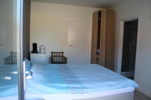 ein Schlafzimmer mit einem Bett mit einer blauen Decke in der Unterkunft Logie Rotem in Dilsen-Stokkem