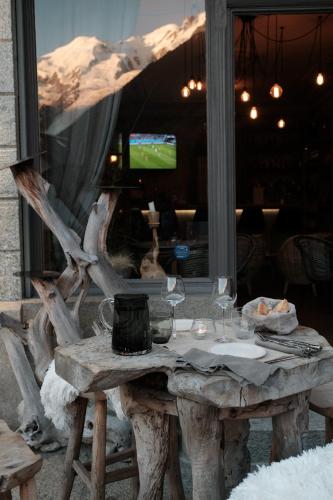 a wooden table with wine glasses on top of it at Eden Hotel, Apartments and Chalet Chamonix Les Praz in Chamonix-Mont-Blanc