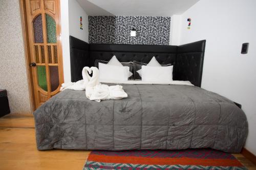 two white swans sitting on top of a bed at Hotel Inka King in Ollantaytambo