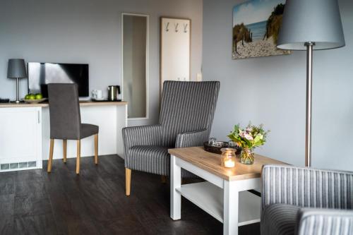 a living room with two chairs and a table at Strandhafer Aparthotel in Warnemünde