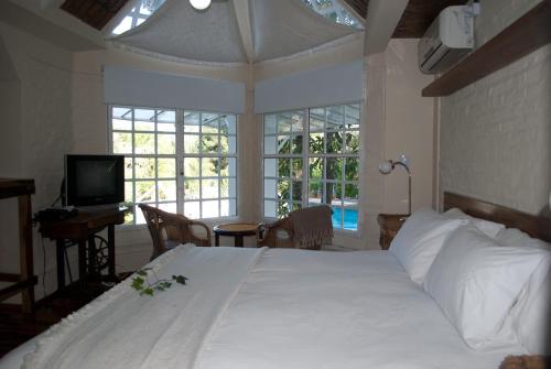 a bedroom with a large white bed and windows at Espacio Domu in Cañuelas