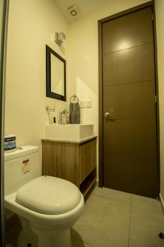 a bathroom with a toilet and a sink and a door at NIZA FIVE Luxury Beach Apartments in Puerto Vallarta