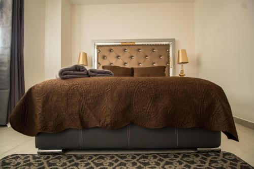 1 dormitorio con 1 cama grande y edredón marrón en NIZA FIVE Luxury Beach Apartments, en Puerto Vallarta