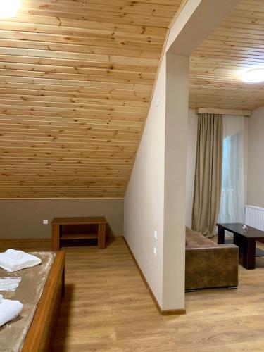 a room with two beds and a wooden ceiling at Hotel Patriot in Mestia