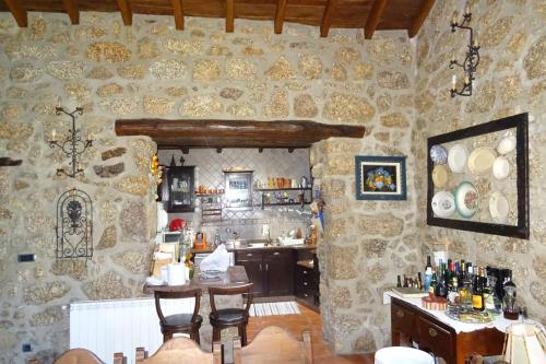 a kitchen with a stone wall with a table and chairs at Quinta Vale da Ginjeira in Quinta da Carrapata