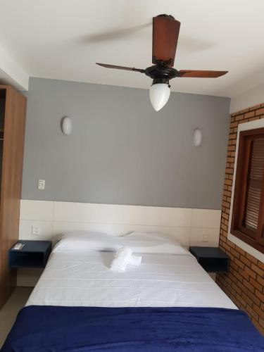 a bedroom with a bed with a ceiling fan at Beach House Floripa - Sunset in Florianópolis