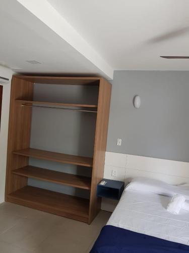 a bedroom with a bed and a wooden cabinet at Beach House Floripa - Sunset in Florianópolis