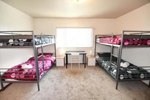 a room with three bunk beds and a table at Hostel Style Shared Room in Daly City