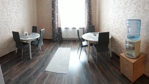 チェレポヴェツにあるHotel Lyuksemburgのテーブル2台、椅子、給水機が備わる客室です。