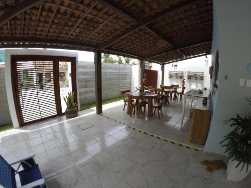 une terrasse ouverte avec une table et des chaises. dans l'établissement Pousada Corais dos Milagres, à São Miguel dos Milagres