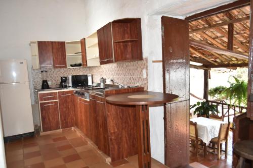 cocina con armarios de madera y mesa en Hospedaje Don Juan, en Barichara