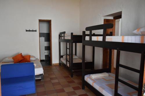 Zimmer mit 3 Etagenbetten und einem Sofa in der Unterkunft Hospedaje Don Juan in Barichara