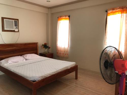 a bedroom with a bed and a fan at D's Oceanview Beach Resort in Siquijor