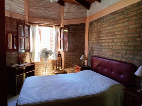 Los Talas Calamuchita في سانتا روزا دي كالموتشيتا: غرفة نوم بسرير وجدار من الطوب