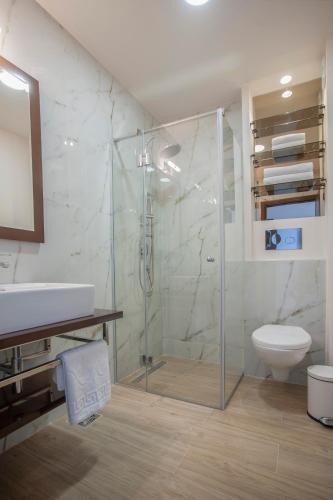 a bathroom with a shower and a toilet and a sink at Hotel Twelve by Aycon in Budva
