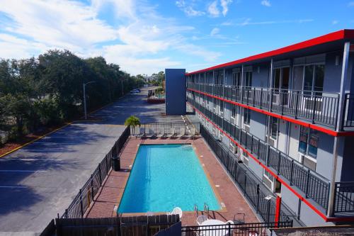 a building with a swimming pool next to a building at Travelodge by Wyndham Orlando at Heart of International Drive in Orlando
