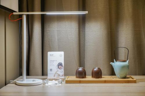 a table with a vase and other items on it at Atour Hotel Harbin Convention and Exhibition Center in Harbin