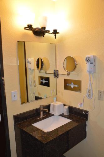 a bathroom with a sink and a mirror at Burnsville Inn & Suites in Burnsville