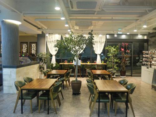 een restaurant met houten tafels, stoelen en planten bij Ehwa In Myeongdong in Seoul