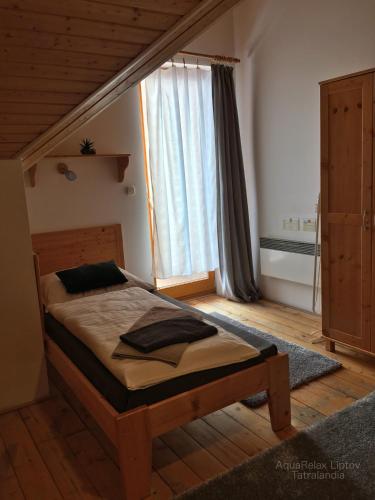 a bedroom with a bed in front of a window at AquaRelax Liptov Tatralandia in Liptovský Mikuláš