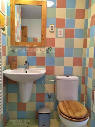 a bathroom with a sink and a toilet and a mirror at AquaRelax Liptov Tatralandia in Liptovský Mikuláš