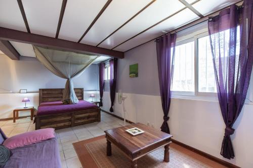 ein Schlafzimmer mit einem Bett und einem Tisch in einem Zimmer in der Unterkunft Villa Tangor in Petite Île