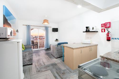 a kitchen and living room with a counter top at Tonel Apartamentos Turisticos in Sagres