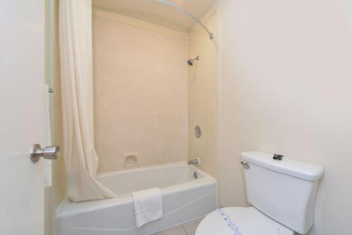 a bathroom with a tub and a toilet and a shower at Atascadero Inn in Atascadero