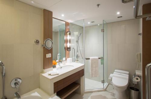 a bathroom with a sink and a shower and a toilet at Shangri-La Qingdao - May Fourth Square in Qingdao