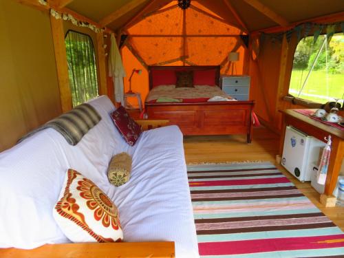 a room with a bed in a tent at Omarama Oasis - Permaculture Glamping in Pohara