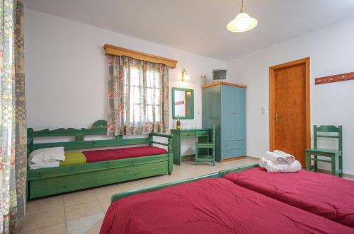 a bedroom with two beds and a desk at Despina Hotel in Agia Anna Naxos