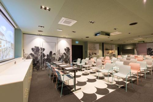 a conference room with tables and chairs and a screen at Grand Hôtel Bristol in Colmar