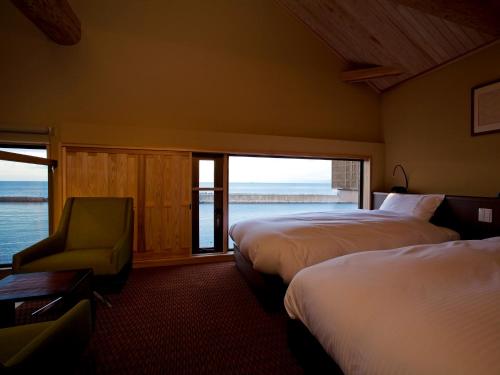 una camera d'albergo con due letti e una finestra di Amahara a Sumoto