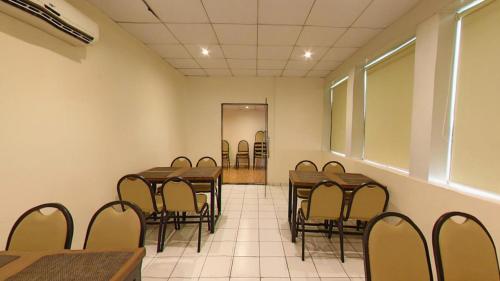 a conference room with tables and chairs and a mirror at Hotel Jyoti in Rajkot