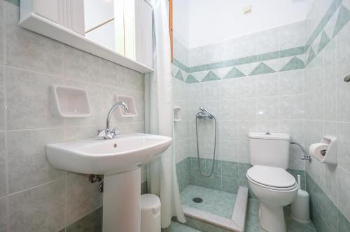 uma casa de banho com um lavatório, um WC e um chuveiro em Despina Hotel em Agia Anna (Naxos)