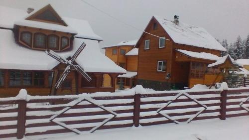 a house with a fence covered in snow at Marichka in Yablunytsya
