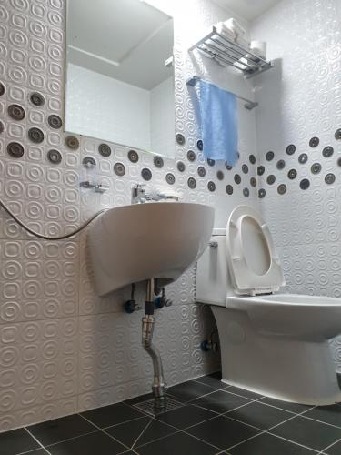 a bathroom with a sink and a toilet and a mirror at Jeongga Hanok in Jeonju