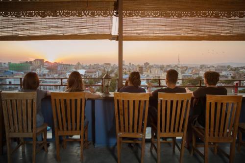 a group of people sitting at a table watching the sunset at Ostello Bello Mandalay in Mandalay
