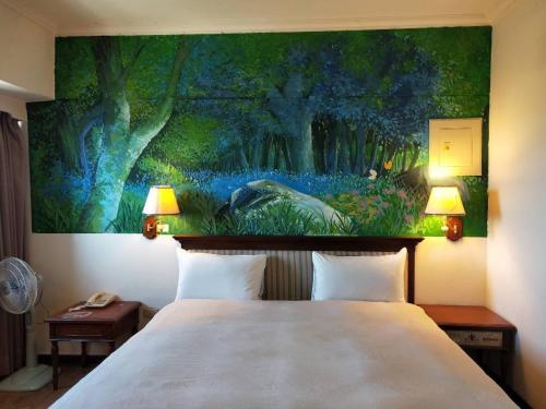 Little Paradise Inn في هنغتشون أولد تاون: غرفة نوم مع لوحة فوق سرير مع مصباحين