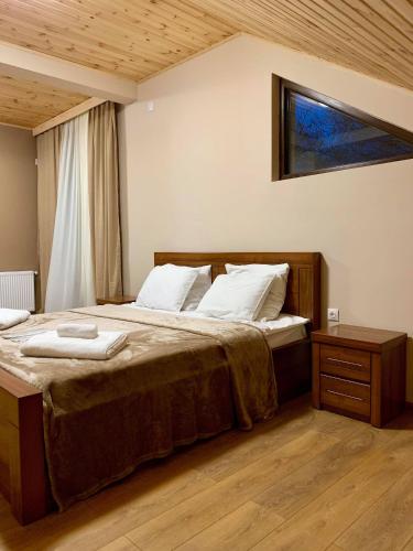 a bedroom with a large bed with a wooden frame at Hotel Patriot in Mestia