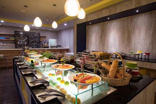 une ligne de buffet avec de nombreuses assiettes de nourriture dans un restaurant dans l'établissement ibis Styles Kuala Lumpur Sri Damansara, à Petaling Jaya