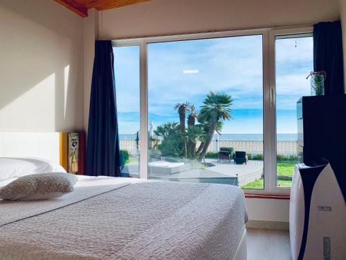 a bedroom with a large window with a view of the ocean at Boutique home the beach in Malgrat de Mar