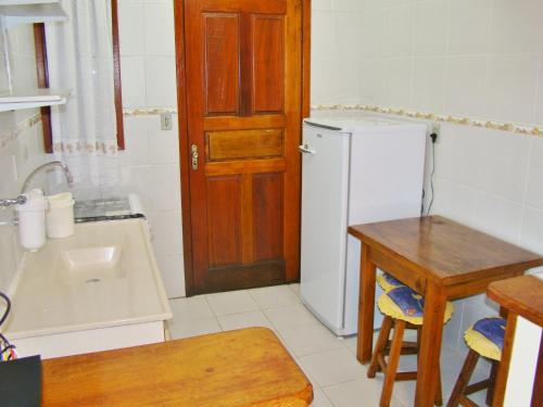a kitchen with a white refrigerator and a wooden door at Alpenhaus Pousada in Campos do Jordão