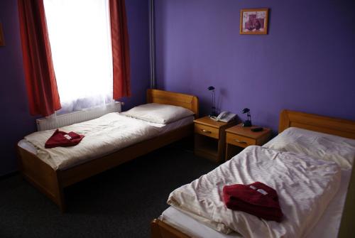 a bedroom with two beds and a window and a phone at Pension Zlata Noha in Bratislava